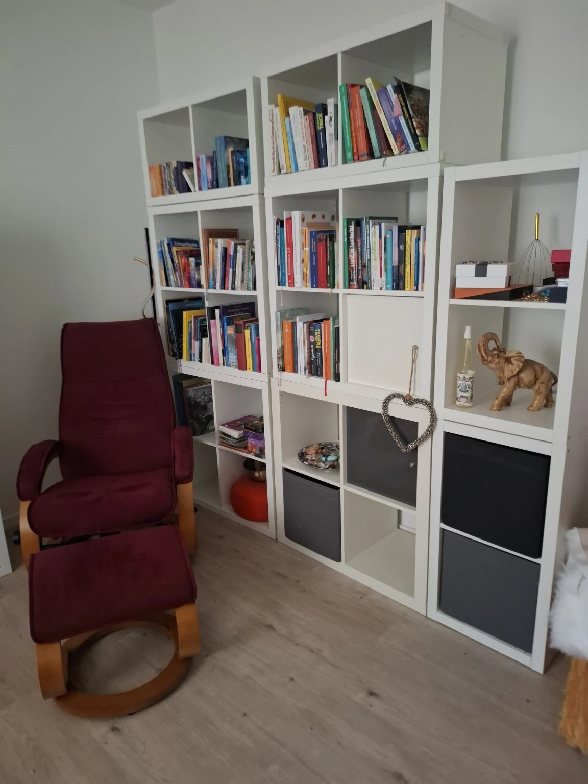 Ruhiger Raum mit einem weinroten Sessel und Bücheregalen